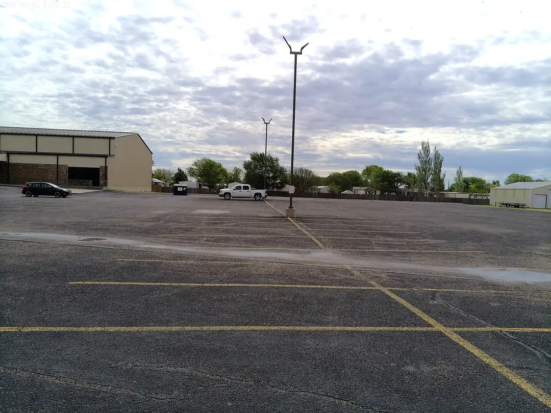 Brick wing of Arden Road Baptist Church beyond the parking lot