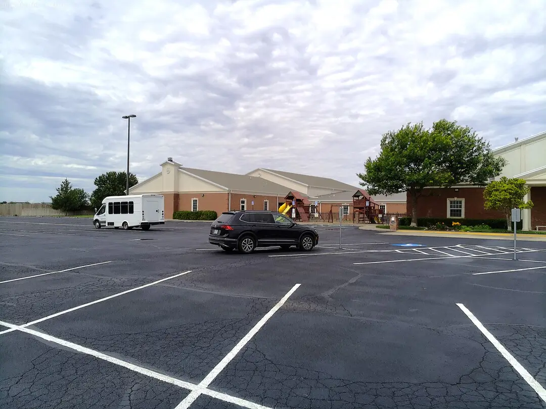 Church of Christ of the Colonies campus beyond a striped parking lot
