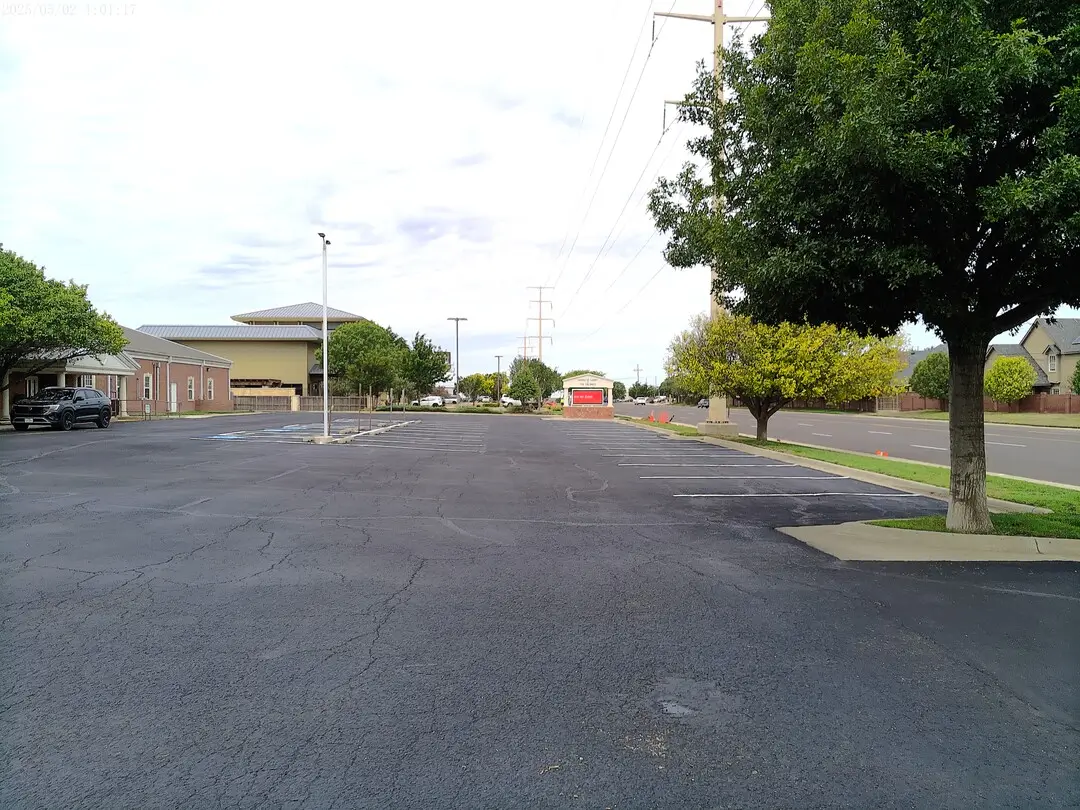 Tree-lined edge of the Church of Christ of the Colonies parking lot