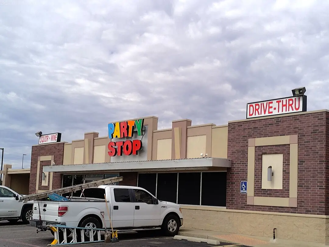 Party Stop storefront with colorful signage and a drive-thru sign