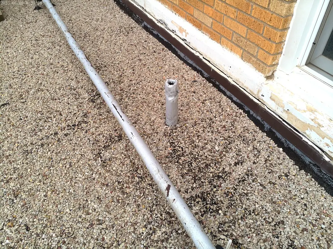 Conduit run along the gravel roof edge of the DPS building