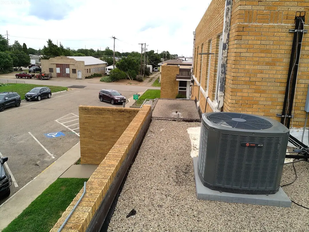 Rooftop condenser beside the brick wall of the DPS building in Childress