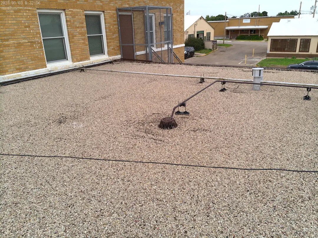 Gravel roof and drains along the brick wall of the DPS building