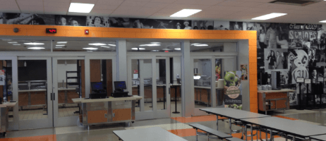 Remodeled school cafeteria serving line with orange accents and stainless counters by A & S General Contractors