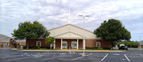 Brick church with a white steeple and a newly paved parking lot by A & S General Contractors