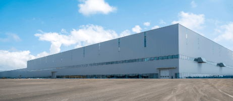 Large white metal warehouse with a long, windowless facade