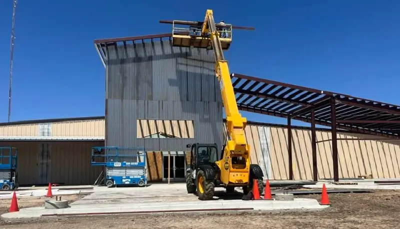 Friona Community Center under construction with a telehandler and steel canopy frame
